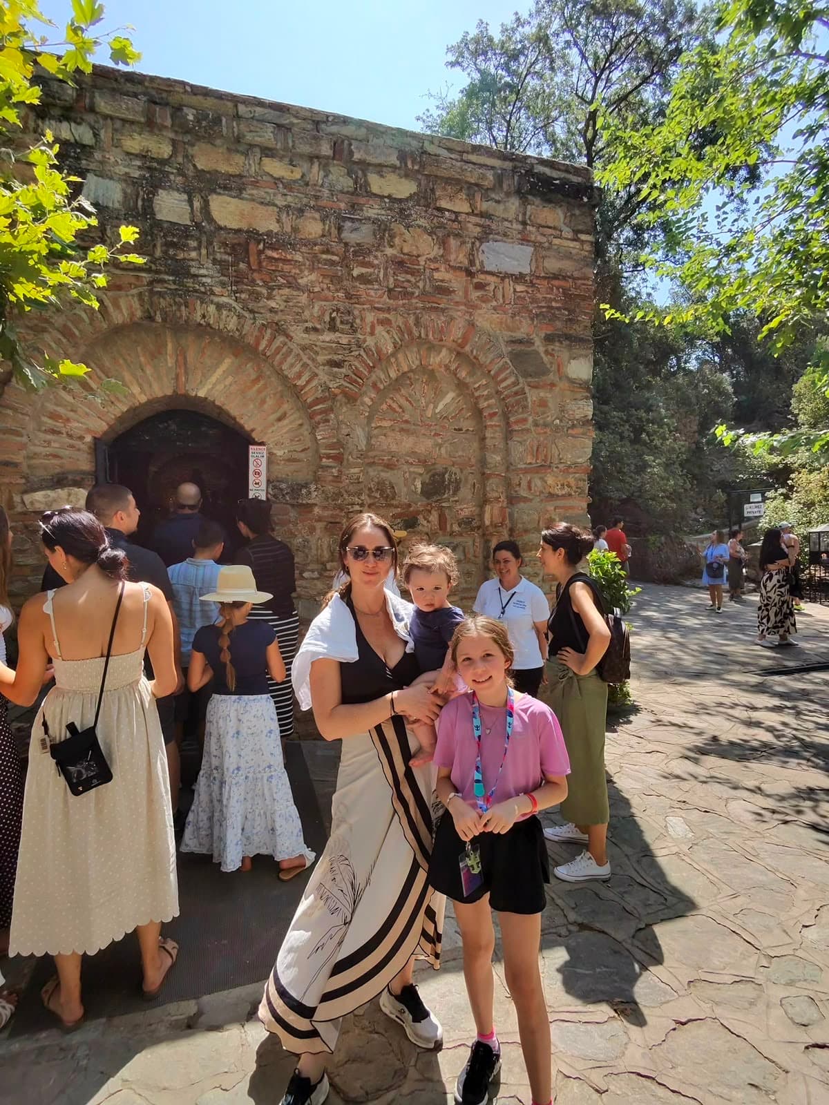 Eine Familie besucht die Steinkapelle am Haus der Jungfrau Maria bei Ephesus.
