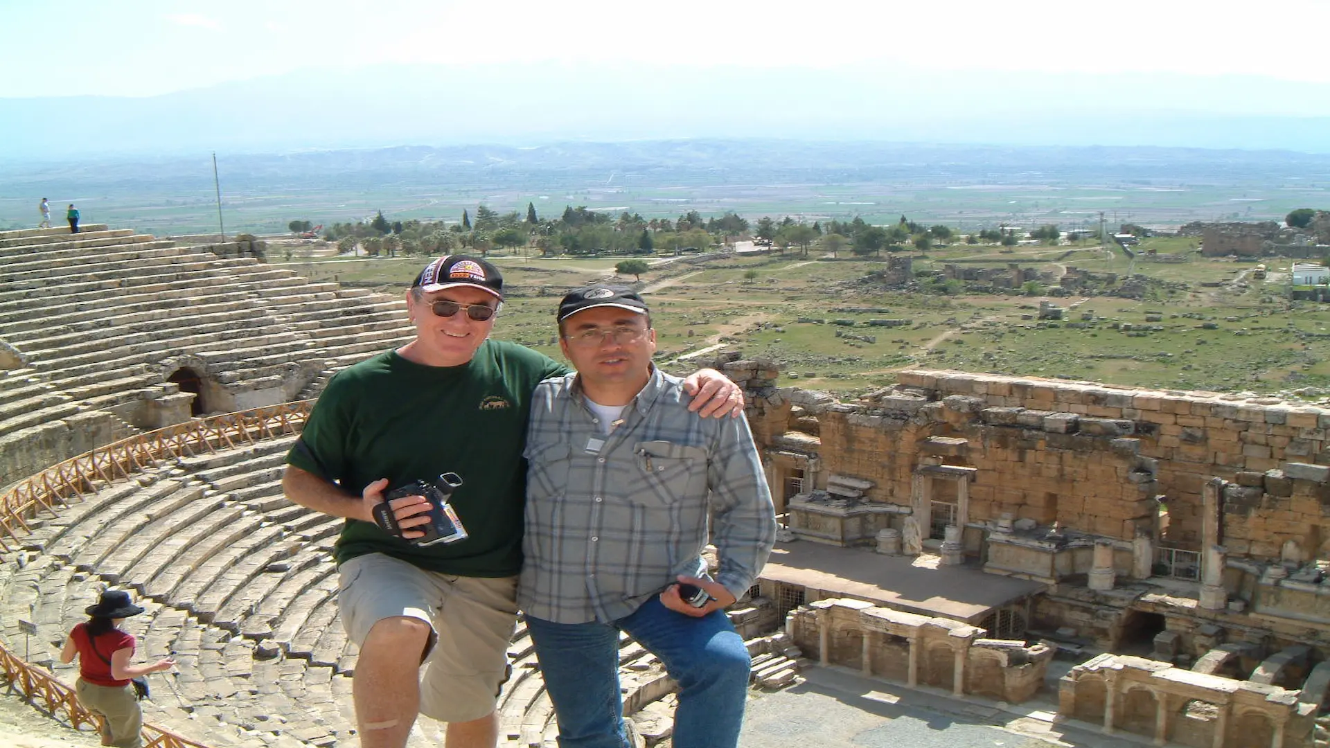 Two men enjoying the panoramic view from the top of an ancient theater during a private guided ruins tour.