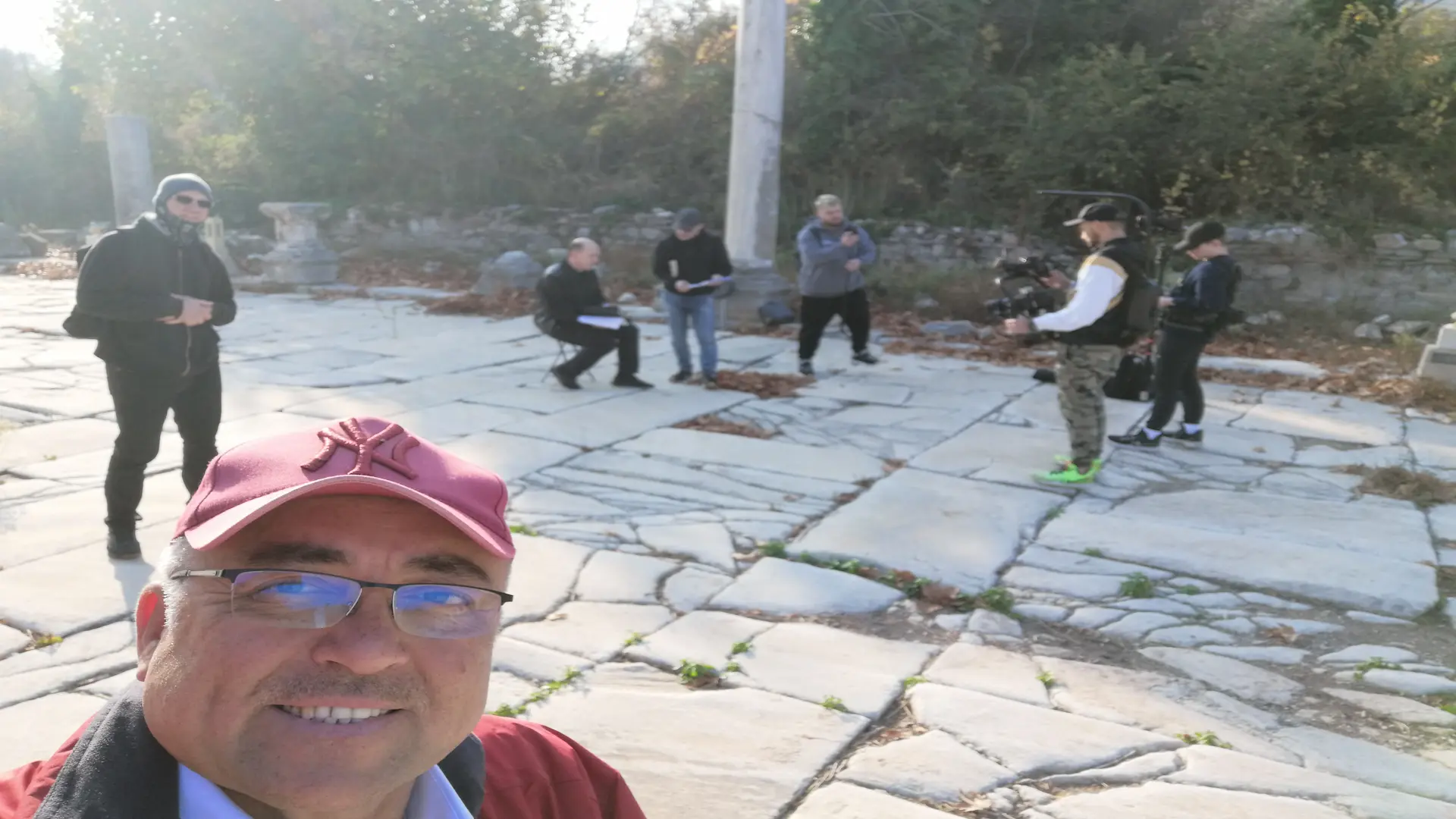 Ephesus tour guide taking a selfie with a film crew and visitors on the historic streets of the ancient city.