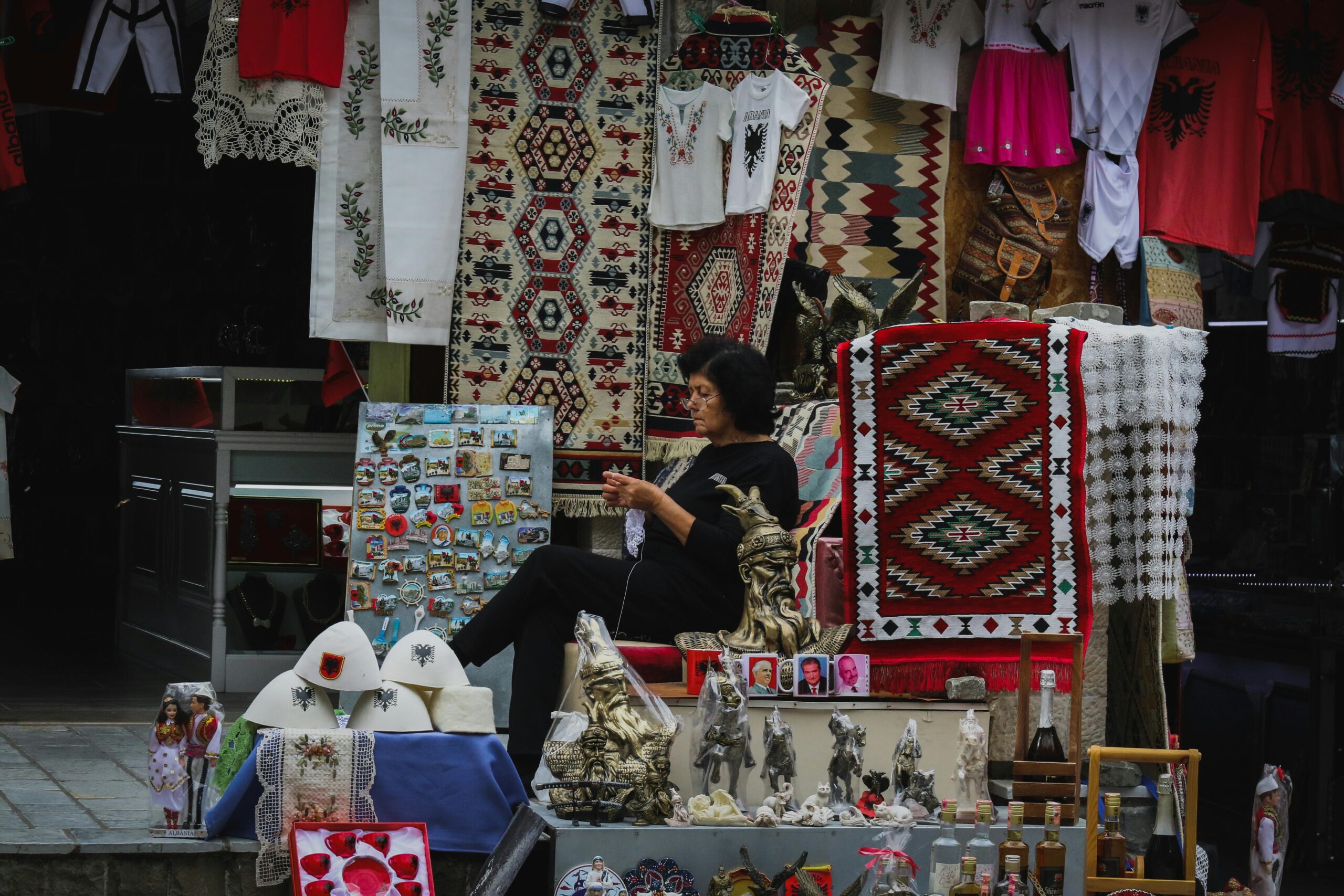 Street market scene in Krujë, Albania featuring handmade souvenirs and traditional textiles.