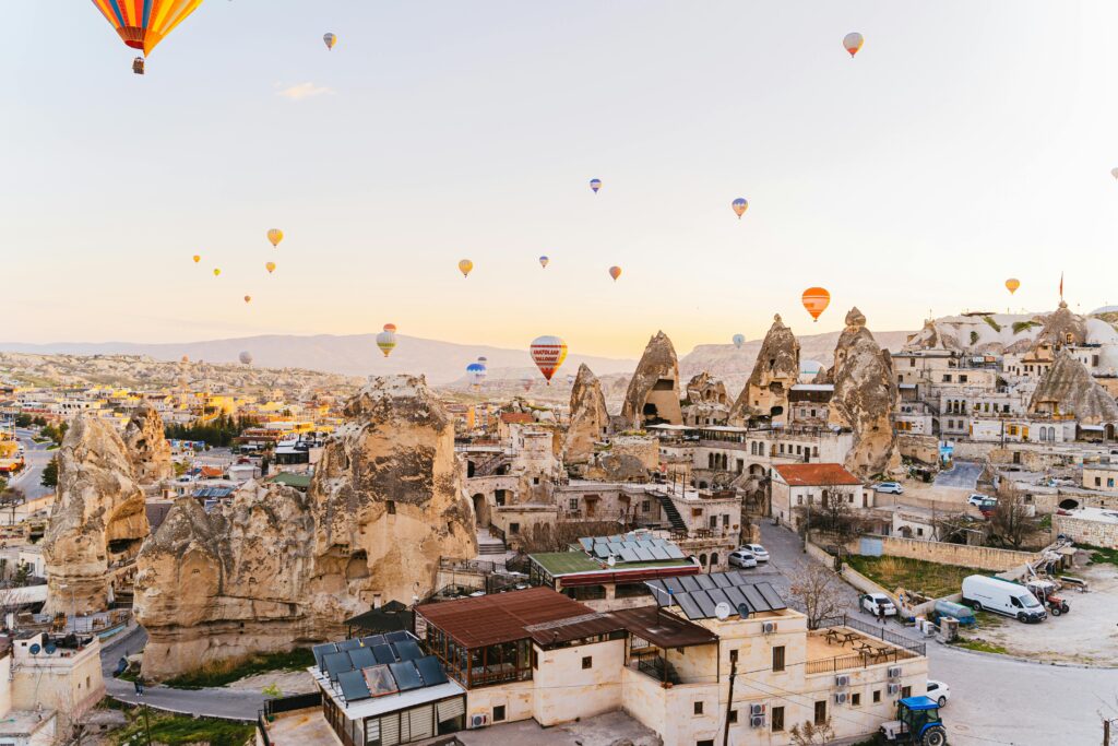 Captivating aerial view of hot air balloons over the unique Cappadocia landscape at sunrise.